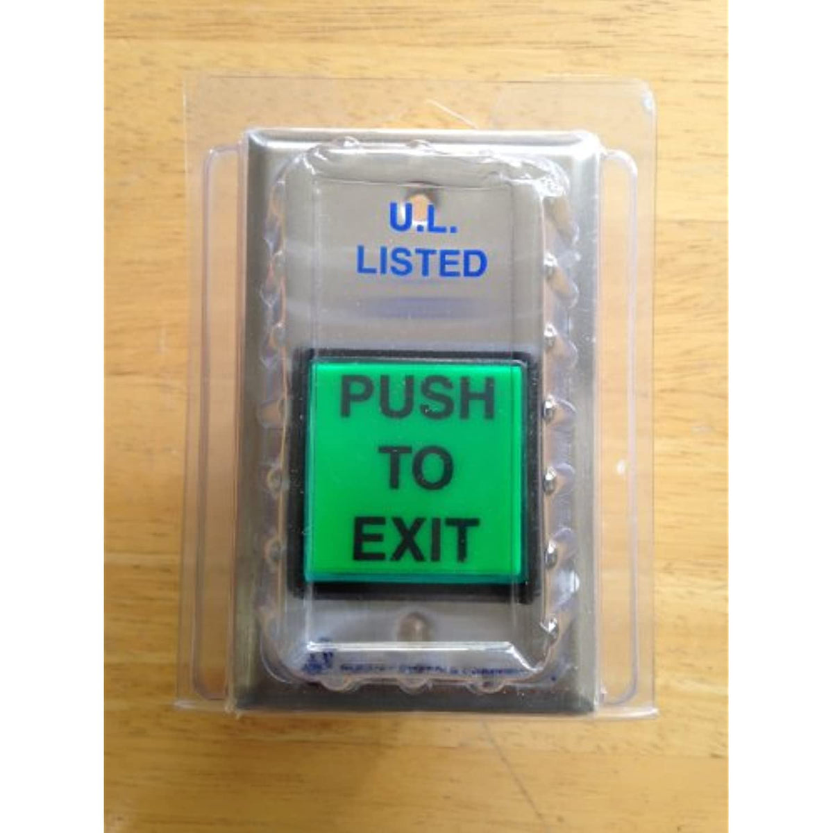 Push to exit button in packaging on a wooden surface