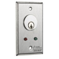 metal wall panel with red and green light indicators and key slot on white background