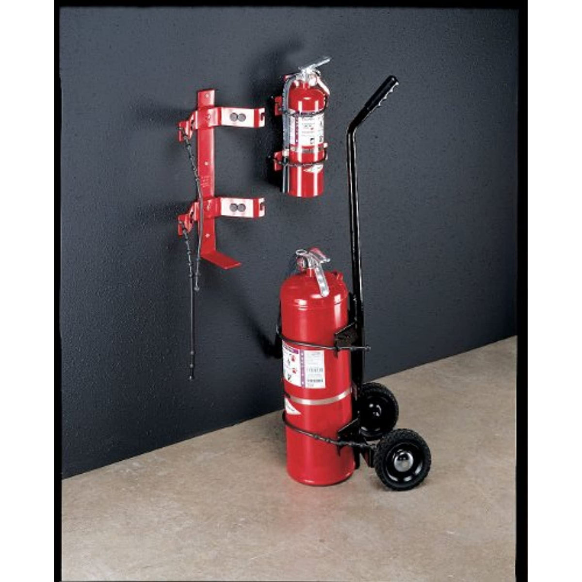 Fire extinguishers on a stand against a dark wall.