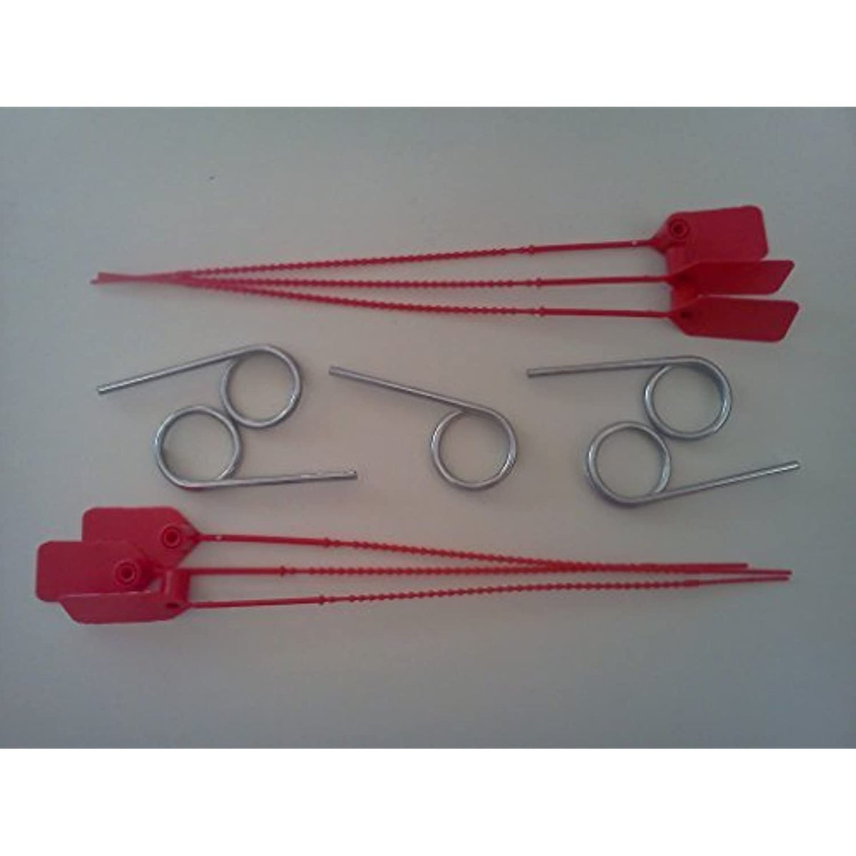 Six red plastic tamper-evident seals and five silver metal pull pins